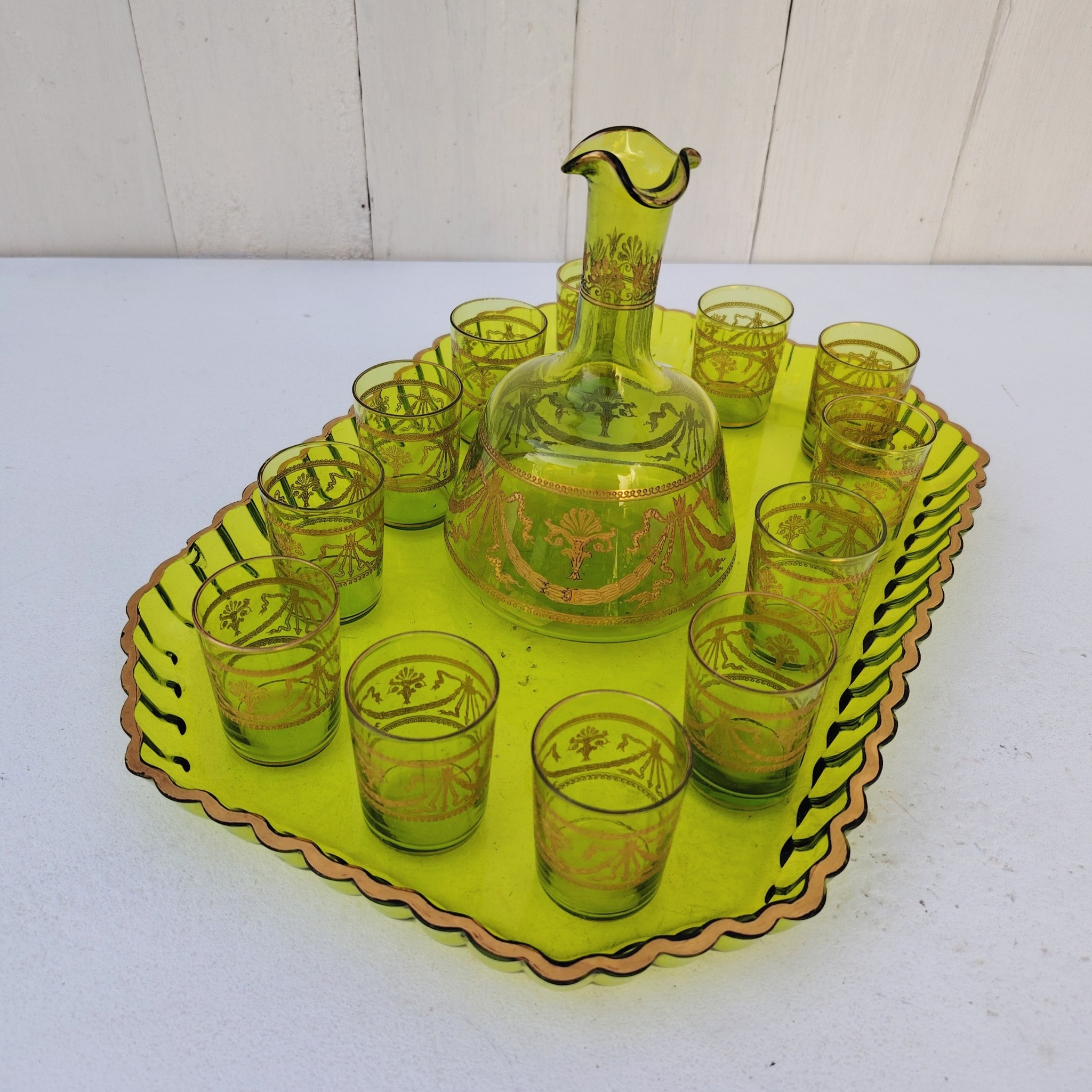 Service à liqueur en cristal de Saint Louis . Le service est composé de 12 verres à liqueur, d'une carafe et d'un plateau. Cristal teinté vert avec dorure. Non estampillé car datant d'avant 1936. Petites rayures d'usage. Manque certainement le bouchon de la carafe. Une paillette sur le rebord du plateau Bon état général. Dimension plateau : 30,5 cm x 21 cm Hauteur verre : 5 cm Diamètre verre : 3,5 cm Hauteur Carafe : 14,5 cm