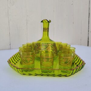 Service à liqueur en cristal de Saint Louis . Le service est composé de 12 verres à liqueur, d'une carafe et d'un plateau. Cristal teinté vert avec dorure. Non estampillé car datant d'avant 1936. Petites rayures d'usage. Manque certainement le bouchon de la carafe. Une paillette sur le rebord du plateau Bon état général. Dimension plateau : 30,5 cm x 21 cm Hauteur verre : 5 cm Diamètre verre : 3,5 cm Hauteur Carafe : 14,5 cm