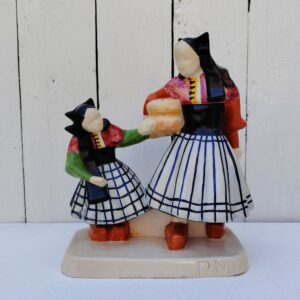Personnages en céramique de Quimper, de la manufactures Henriot, représentant les Ouessantines aux miches de pain crées par Micheau Vernez dans les années 30. Céramique signée sur le dessous. Très bon état. Hauteur : 22,5 cm Dimensions terrasse : 17 x 8 cm
