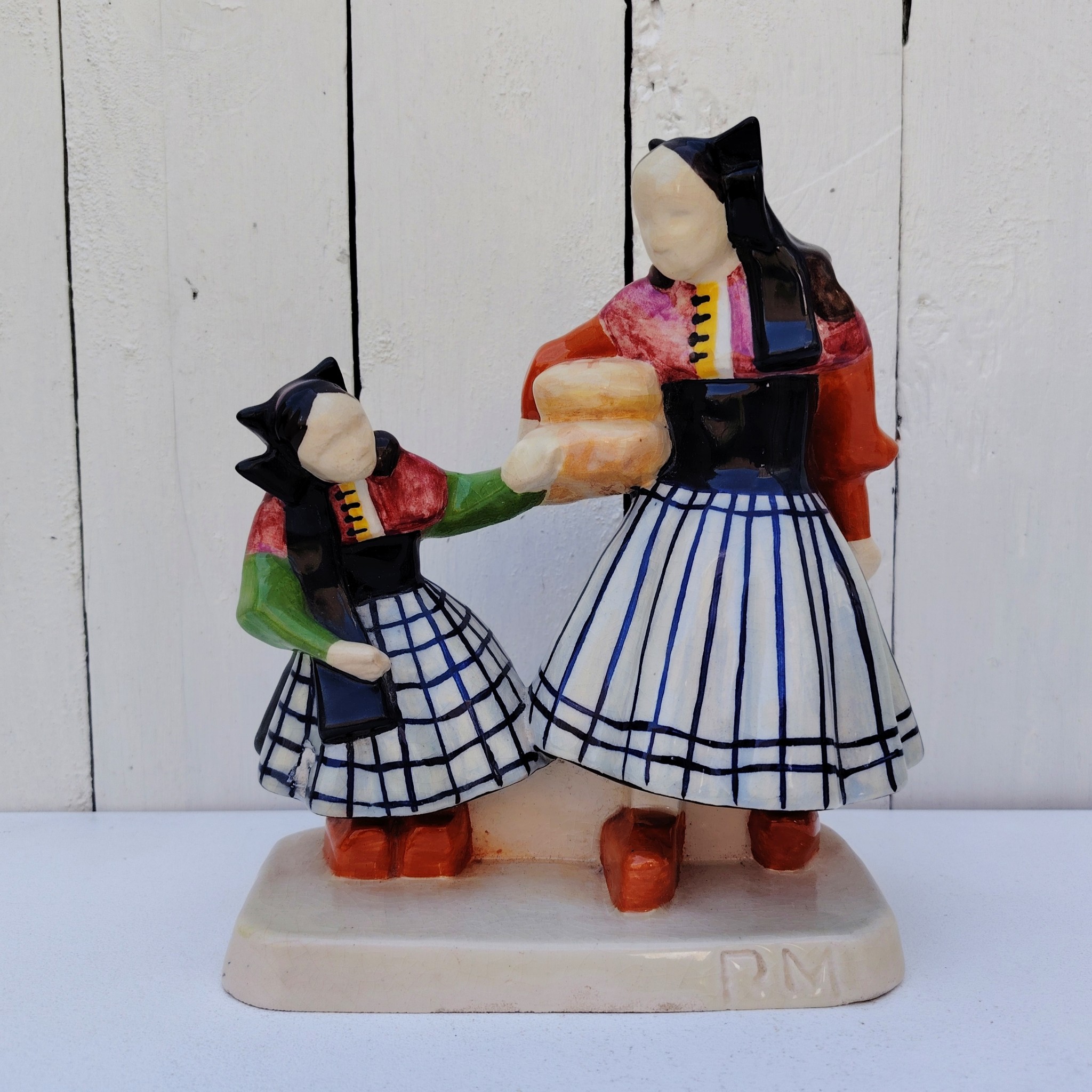 Personnages en céramique de Quimper, de la manufactures Henriot, représentant les Ouessantines aux miches de pain crées par Micheau Vernez dans les années 30. Céramique signée sur le dessous. Très bon état. Hauteur : 22,5 cm Dimensions terrasse : 17 x 8 cm