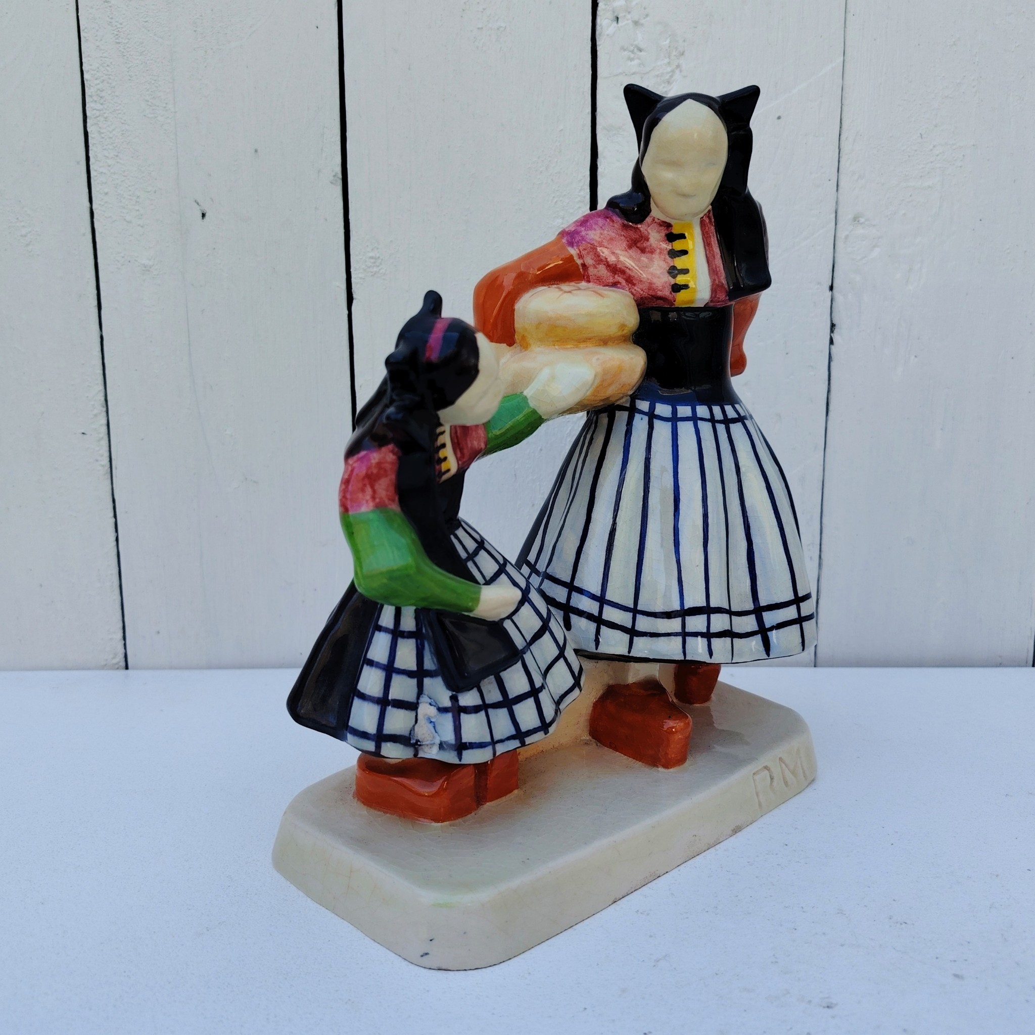 Personnages en céramique de Quimper, de la manufactures Henriot, représentant les Ouessantines aux miches de pain crées par Micheau Vernez dans les années 30. Céramique signée sur le dessous. Très bon état. Hauteur : 22,5 cm Dimensions terrasse : 17 x 8 cm