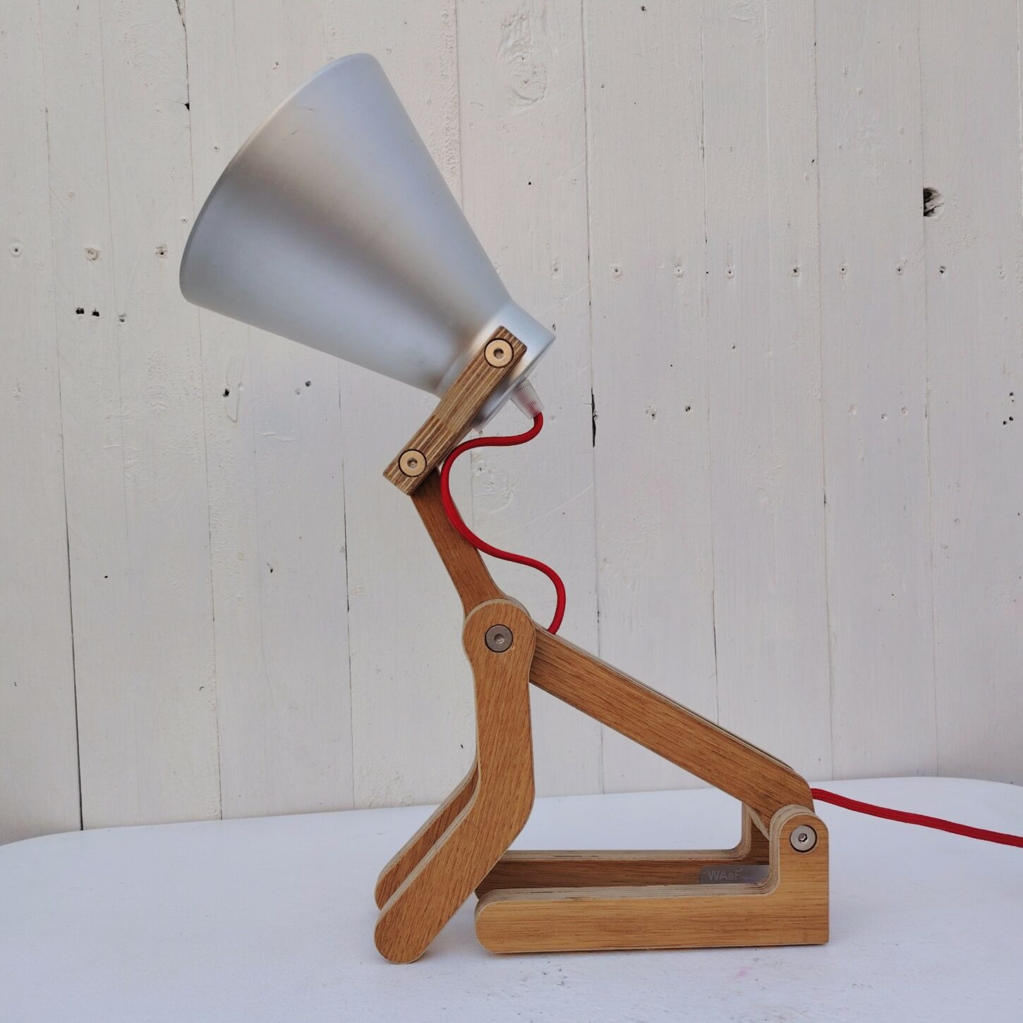 La lampe Waaf conçue par Pierre Stadelmann en 2010 Après avoir effectué un voyage en Italie. Lampe minimaliste qui reproduit de façon remarquable les diverses positions du chien. Fabriquée en France. La lampe est articulée de l'abat- jour représentant la tête et des quatres pattes permettant une multitude de positions.