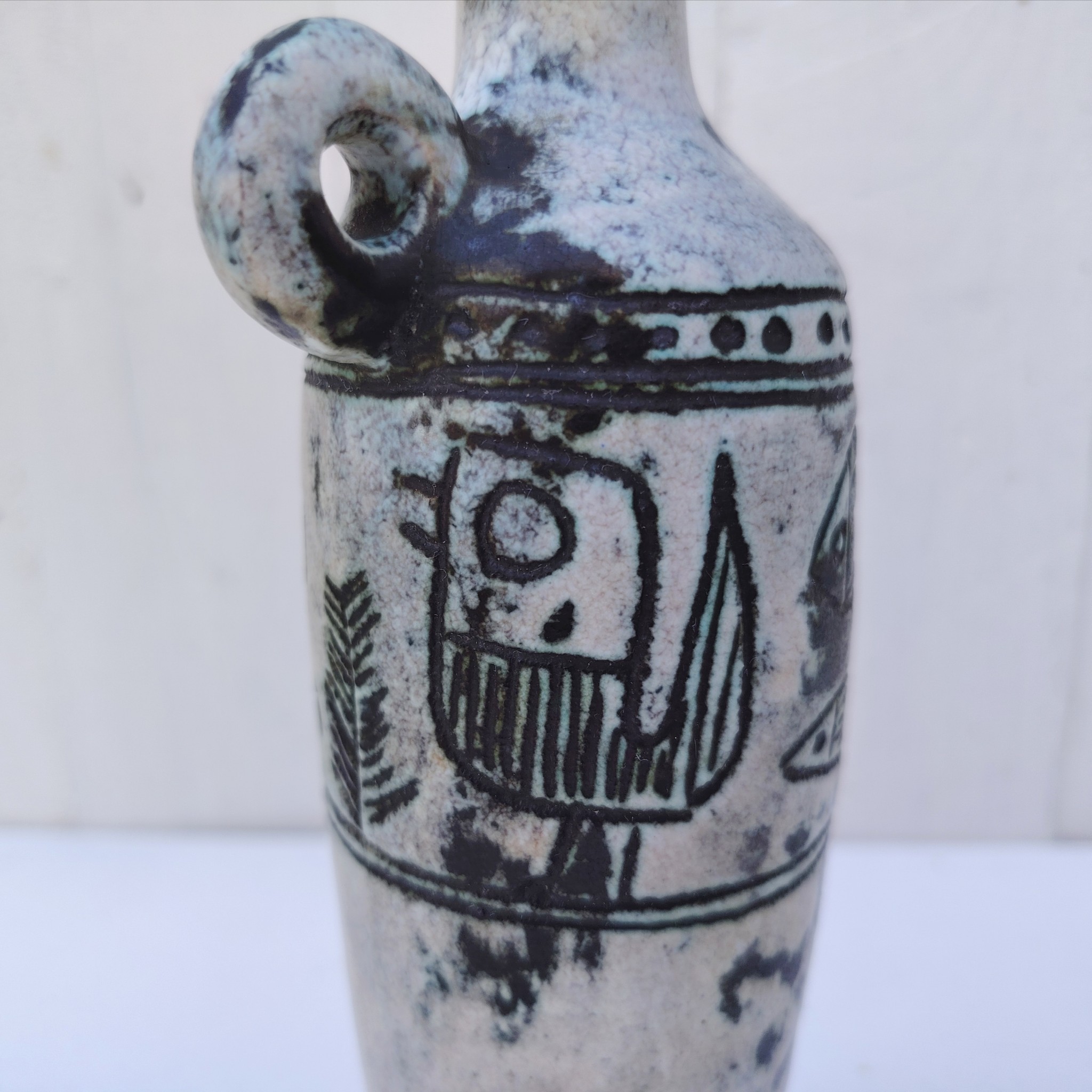 Vase soliflore en forme d'amphore en céramique dans les tons gris, créée par Jacques Blin dans la années 60. Décor incisé de poissons et oiseaux. L'anse a été cassée et recollée pas très visible Bon état général Hauteur : 21,5 cm