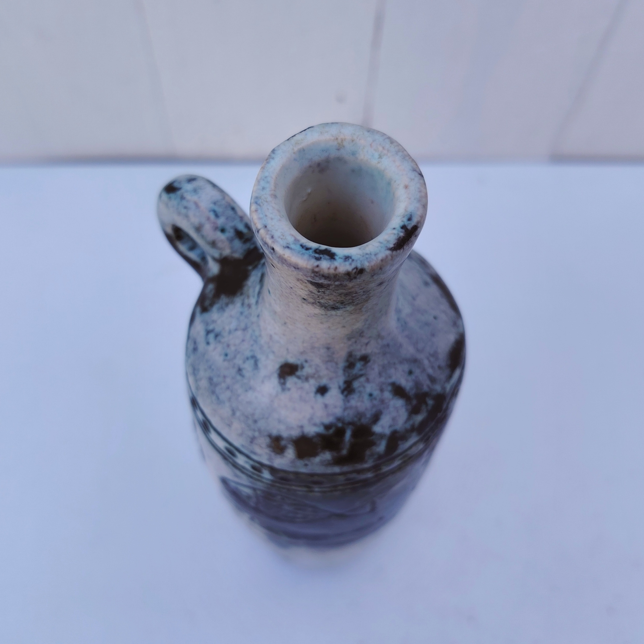 Vase soliflore en forme d'amphore en céramique dans les tons gris, créée par Jacques Blin dans la années 60. Décor incisé de poissons et oiseaux. L'anse a été cassée et recollée pas très visible Bon état général Hauteur : 21,5 cm