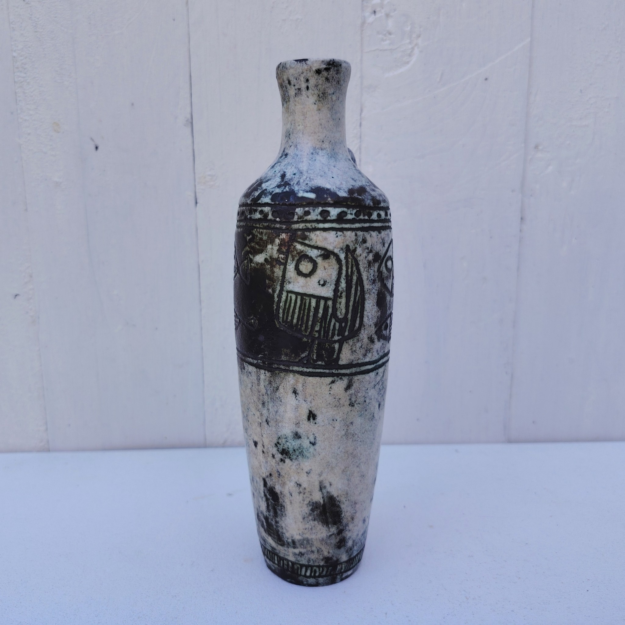 Vase soliflore en forme d'amphore en céramique dans les tons gris, créée par Jacques Blin dans la années 60. Décor incisé de poissons et oiseaux. L'anse a été cassée et recollée pas très visible Bon état général Hauteur : 21,5 cm