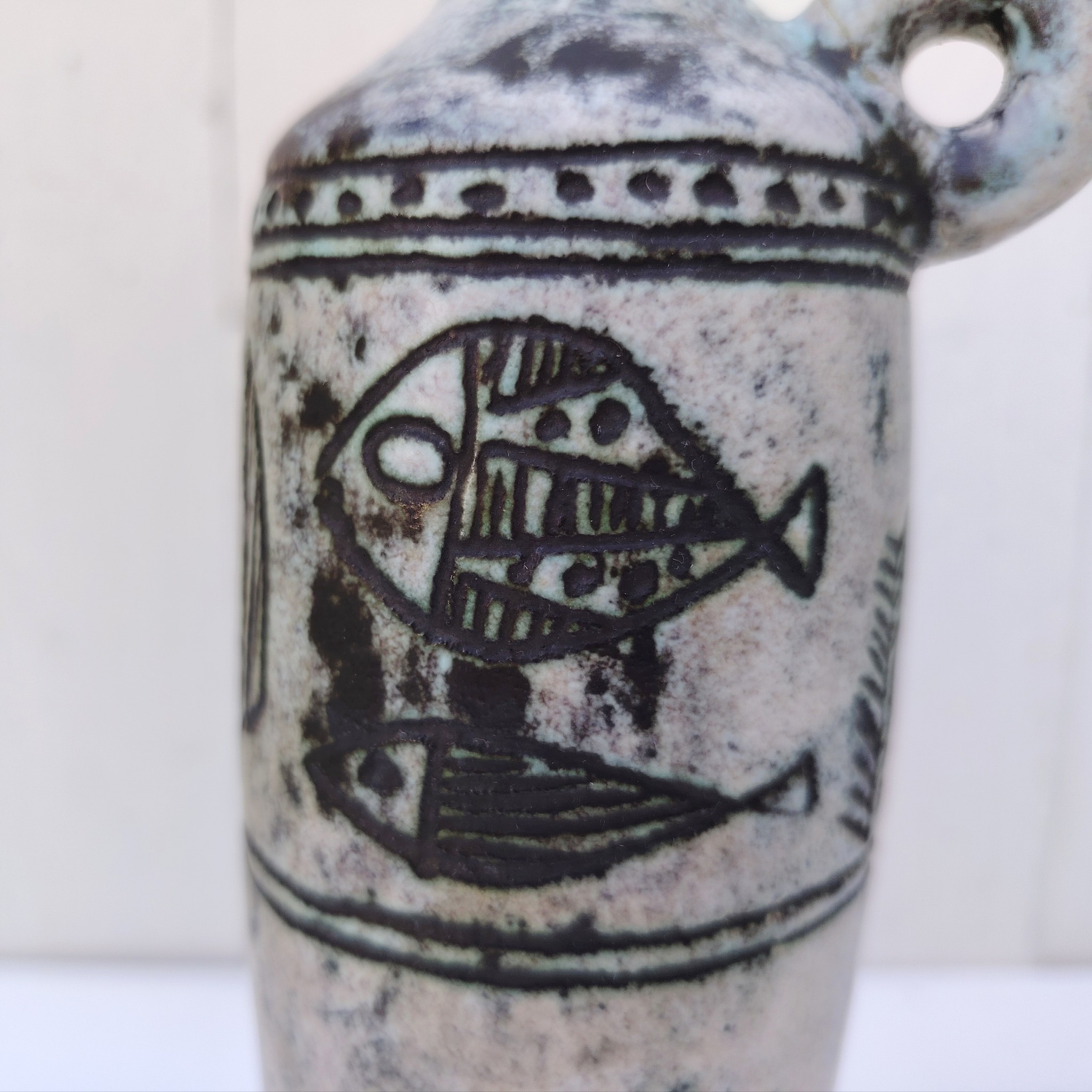 Vase soliflore en forme d'amphore en céramique dans les tons gris, créée par Jacques Blin dans la années 60. Décor incisé de poissons et oiseaux. L'anse a été cassée et recollée pas très visible Bon état général Hauteur : 21,5 cm