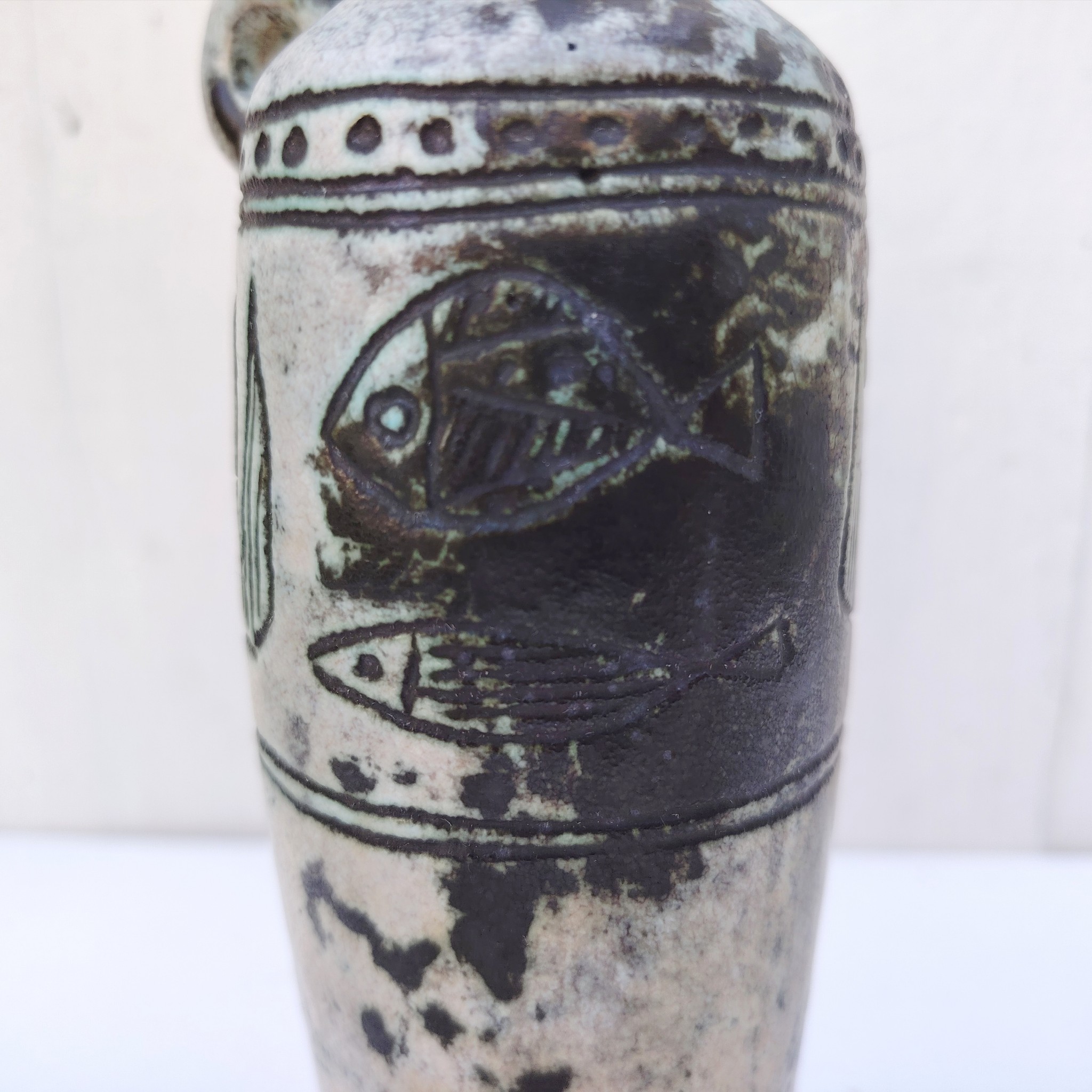 Vase soliflore en forme d'amphore en céramique dans les tons gris, créée par Jacques Blin dans la années 60. Décor incisé de poissons et oiseaux. L'anse a été cassée et recollée pas très visible Bon état général Hauteur : 21,5 cm