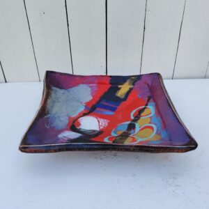 Vide poche en céramique créé par Eduardo Constantino, décor abstrait dans les tons rouge-bleu et doré. Signature en creux sous la base. Décor abstrait. Excellent état. Dimensions : 25 x 26 cm