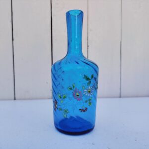 Ancienne bouteille en verre  torsadé de couleur bleu à décor frise florale émaillée Très bon état. Hauteur  : 17 cm