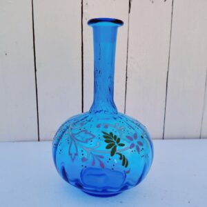 Ancienne carafe en verre effet torsadé de couleur bleu à décor frise florale émaillée Manque le bouchon Très bon état. Hauteur  : 23 cm