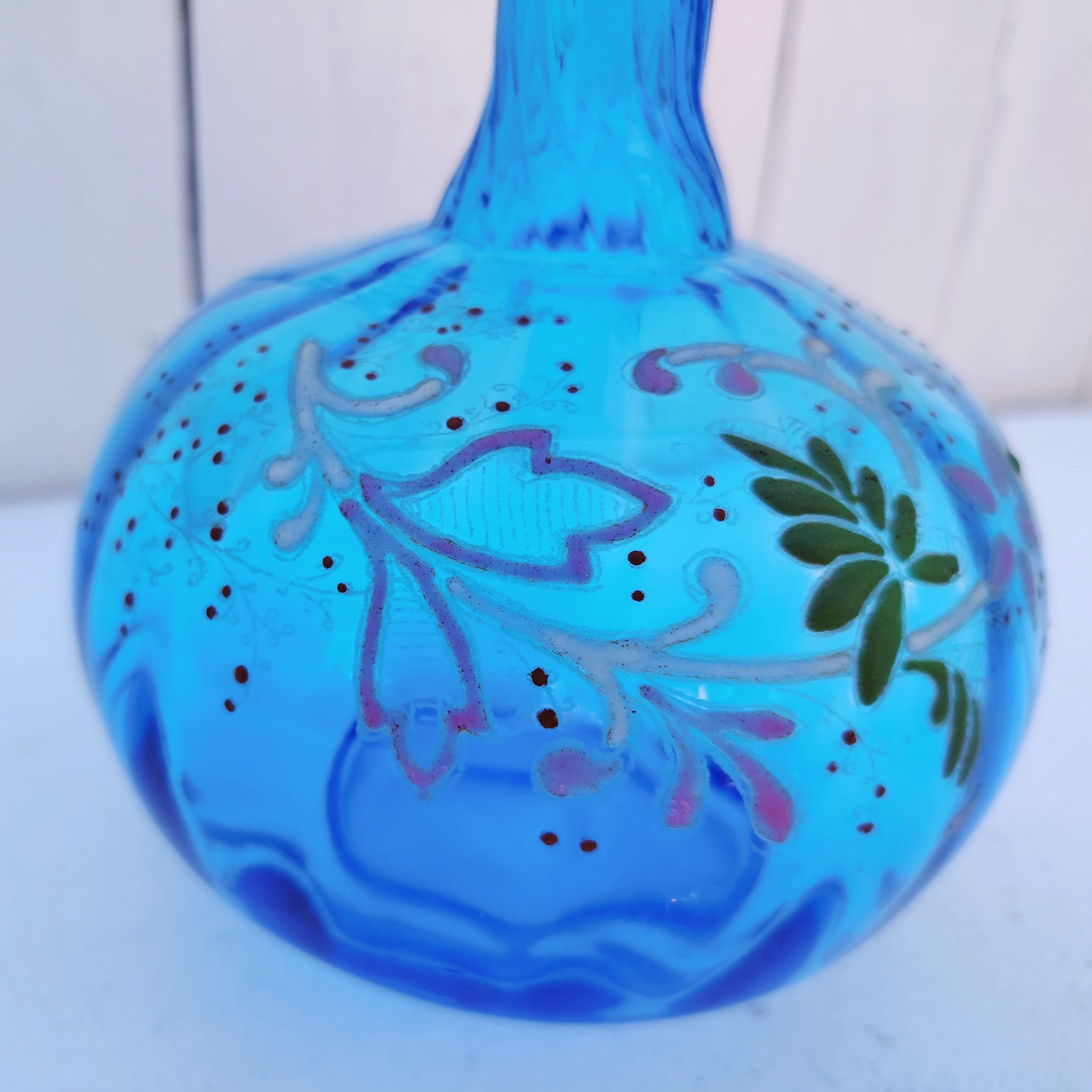 Ancienne carafe en verre effet torsadé de couleur bleu à décor frise florale émaillée Manque le bouchon Très bon état. Hauteur  : 23 cm