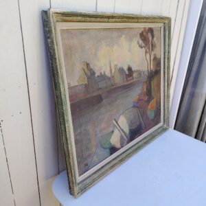 Grand tableau représentant un bord de rivière breton, au premier plan des barques en cale sèche, et au dernier la ville au bord de la rivière. Cadre en bois patiné vert. Une inscription sur le bas a gauche. Bon état général. Dimensions : 74 x 63 cm