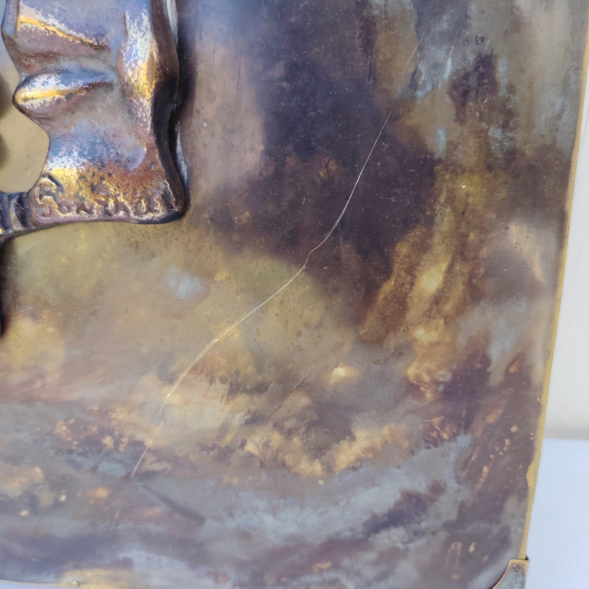 Plaque en cuivre avec deux visages en reliefs au centre qui sont en métal patiné bronze, le tout collé sur un panneau de bois très épais. Signé en bas d'un visage. Bon état général. Dimensions : 38,5 x 30 cm