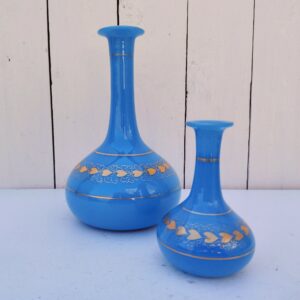 Paire de vase soliflore en opaline bleue turquoise et décor de coeurs dorés de la cristallerie de Baccarat. Epoque Napoléon III. Des manques de dorures dans le décor et aux cols. Bon état général Hauteurs : 20,5 et 12  cm