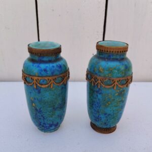 Paires de vases miniatures art déco attribués à Paul Millet, en céramique de sèvres. Dans les tons bleus avec des touches de doré. Un cachet sur le dessous.  Manque le cerclage bronze au pied d'un vase. Bon état général. Hauteur : 8,5 cm