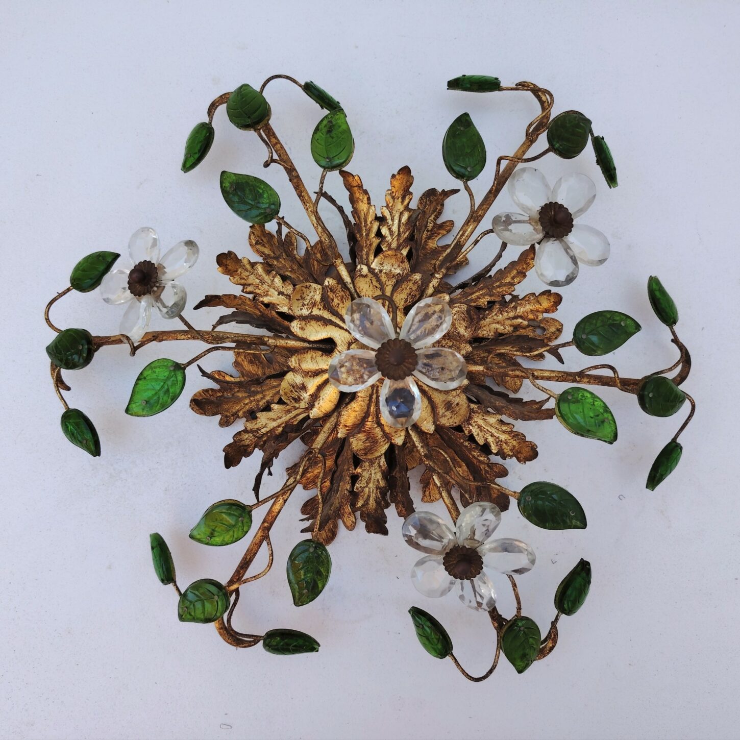  Plafonnier ou applique en métal doré, 6 feux de lumières. Orné de feuilles colorées en vert et fleurs en verre transparent. Attribué à la maison Baguès. légère corrosion sur le structure métal doré. Bon état, Diamètre : 40 cm
