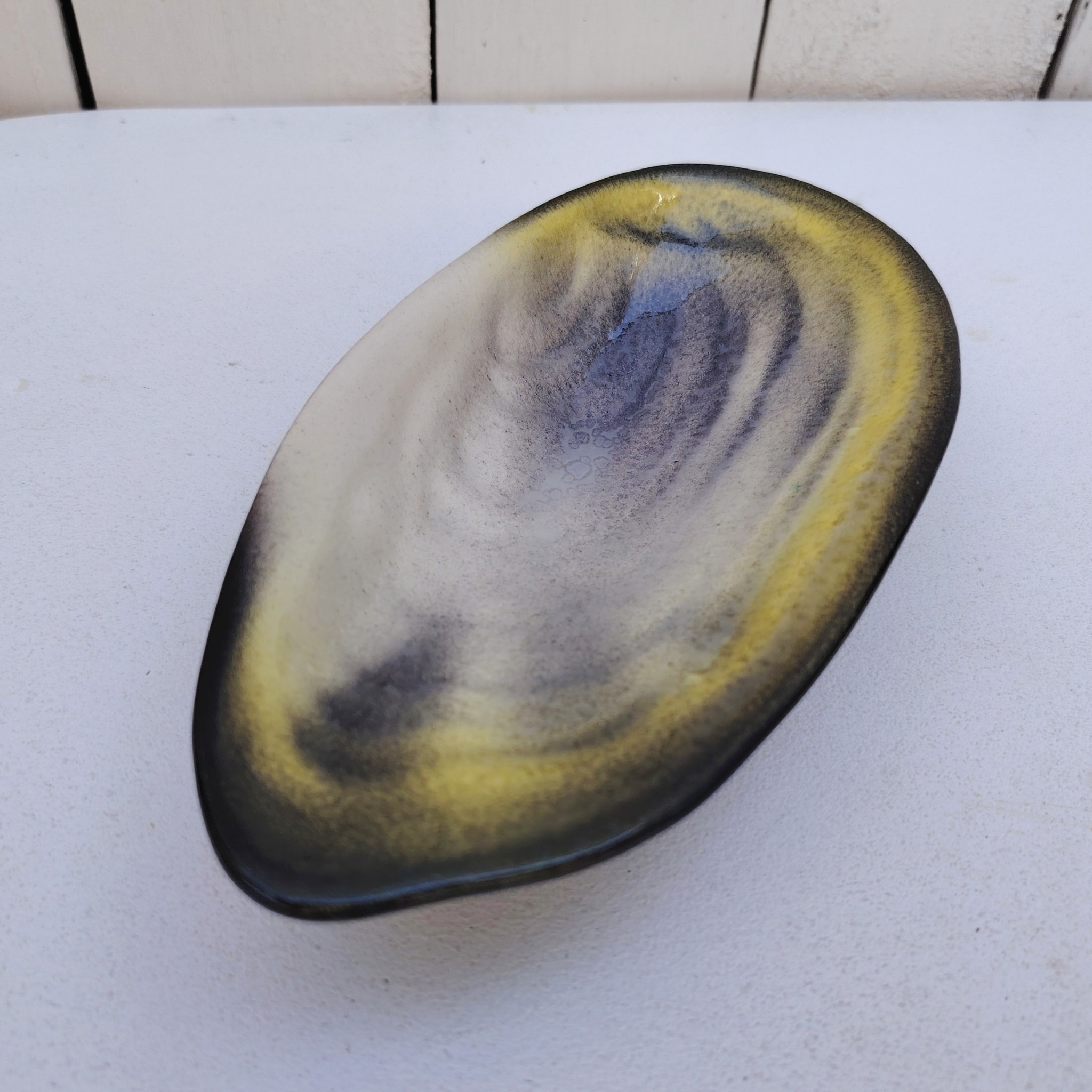 Vide poche en céramique à la  forme de coquille d'huître par Pol Chambost. Dans les tons jaune, gris et noirs. Datant des années 60.  Signature en creux sur le dessous. Parfait état. Dimensions : 19 x 9,5 cm