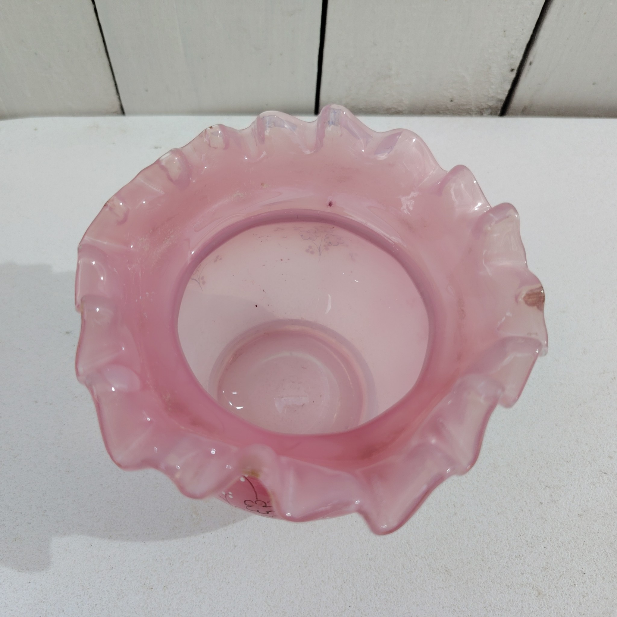Pot couvert pouvant servir de baguier ou autre en verre soufflé de couleur rose, collerette torsadée. Décor de fleur rehaussé de points émaillés blancs en relief. Les fleurs et la prise du couvercle devait être certainement doré car on y voit encore le petites de la dorure. Un petit éclat sur l'intérieur du couvercle non visible quand il est fermé, et traces blanches sur le talon du pot non visible quand il est posé. Bon état général Hauteur avec couvercle : 13 cm Diamètre : 11 cm
