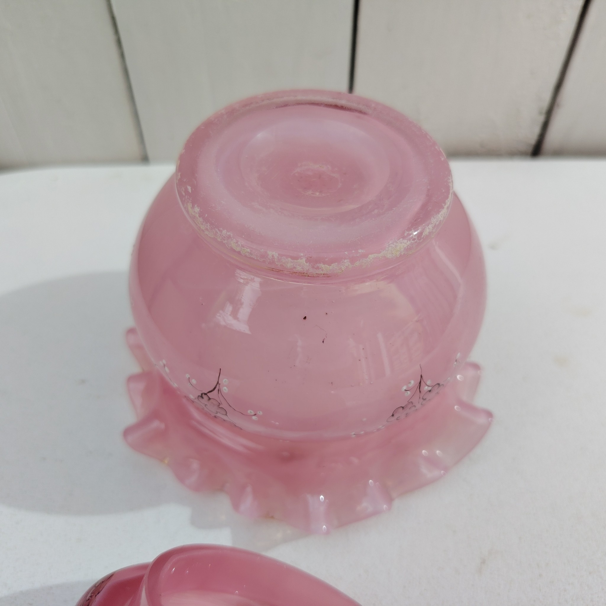 Pot couvert pouvant servir de baguier ou autre en verre soufflé de couleur rose, collerette torsadée. Décor de fleur rehaussé de points émaillés blancs en relief. Les fleurs et la prise du couvercle devait être certainement doré car on y voit encore le petites de la dorure. Un petit éclat sur l'intérieur du couvercle non visible quand il est fermé, et traces blanches sur le talon du pot non visible quand il est posé. Bon état général Hauteur avec couvercle : 13 cm Diamètre : 11 cm