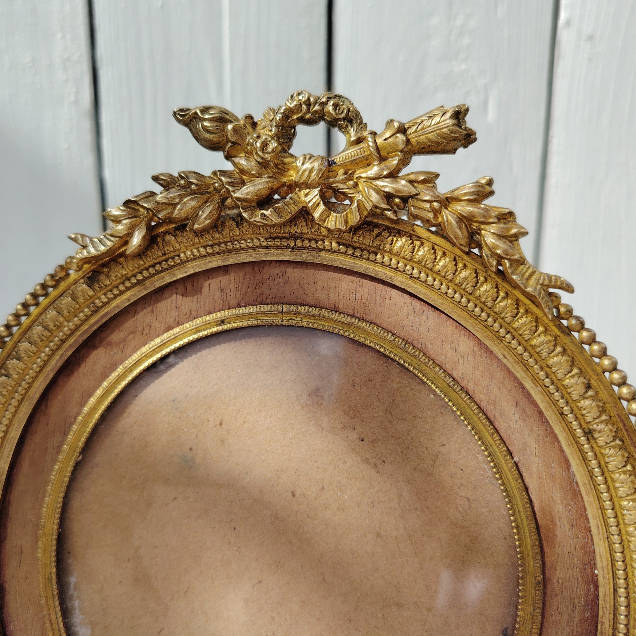 Grand cadre photo chevalet en bronze doré et bois, style Louis XVI, noeud ruban sur le haut.  Une estampille sur l'arrière Bon état général Diamètre : 15,5 cm