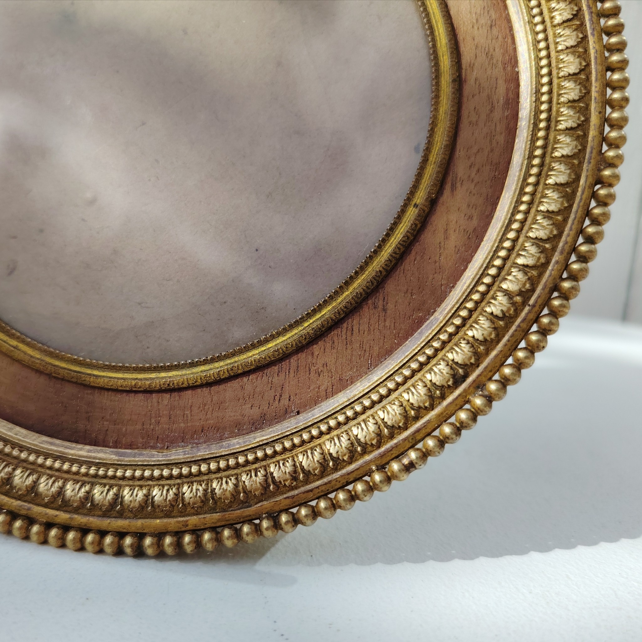 Grand cadre photo chevalet en bronze doré et bois, style Louis XVI, noeud ruban sur le haut.  Une estampille sur l'arrière Bon état général Diamètre : 15,5 cm