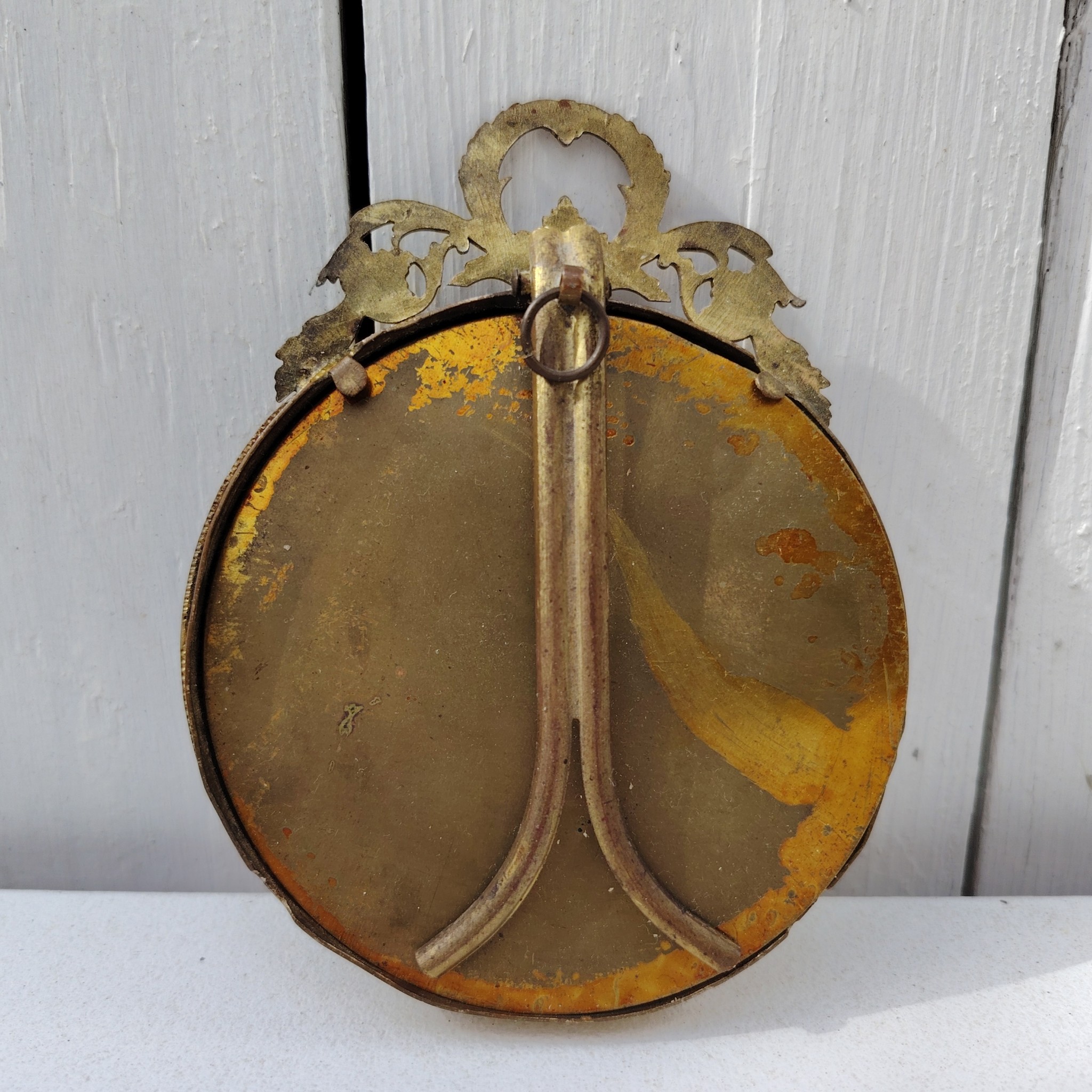 Cadre photo chevalet en bronze doré, style Louis XVI, Ruban sur le haut. Une trace de photo collée sur le rebord intérieur. Bon état général Diamètre : 9 cm