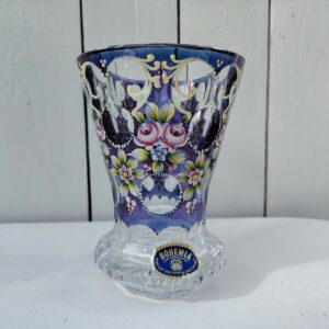 Petit vase en cristal de Bohème à décor floral peint rehaussé de points émaillés en relief. Etiquette d'origine sur le vase. Excellent état  Hauteur : 14 cm Diamètre : 9,5 cm