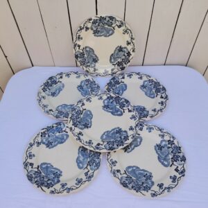 Six assiettes plates terre de fer des salins R&A, modèle les violettes. Deux assiettes ont un fèle à peine visible, traces d'usage Bon état général. Diamètre : 24 cm