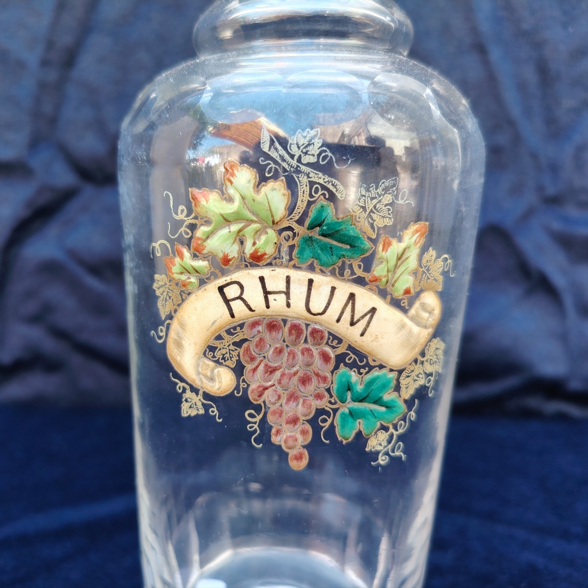 Ancienne bouteille en verre taillé à facette, décor émaillé en relief, marqué Rhum. (Idéale pour faire son rhum arrangé) Des petites traces de calcaire et traces d'usage. Bon état général Hauteur : 30 cm