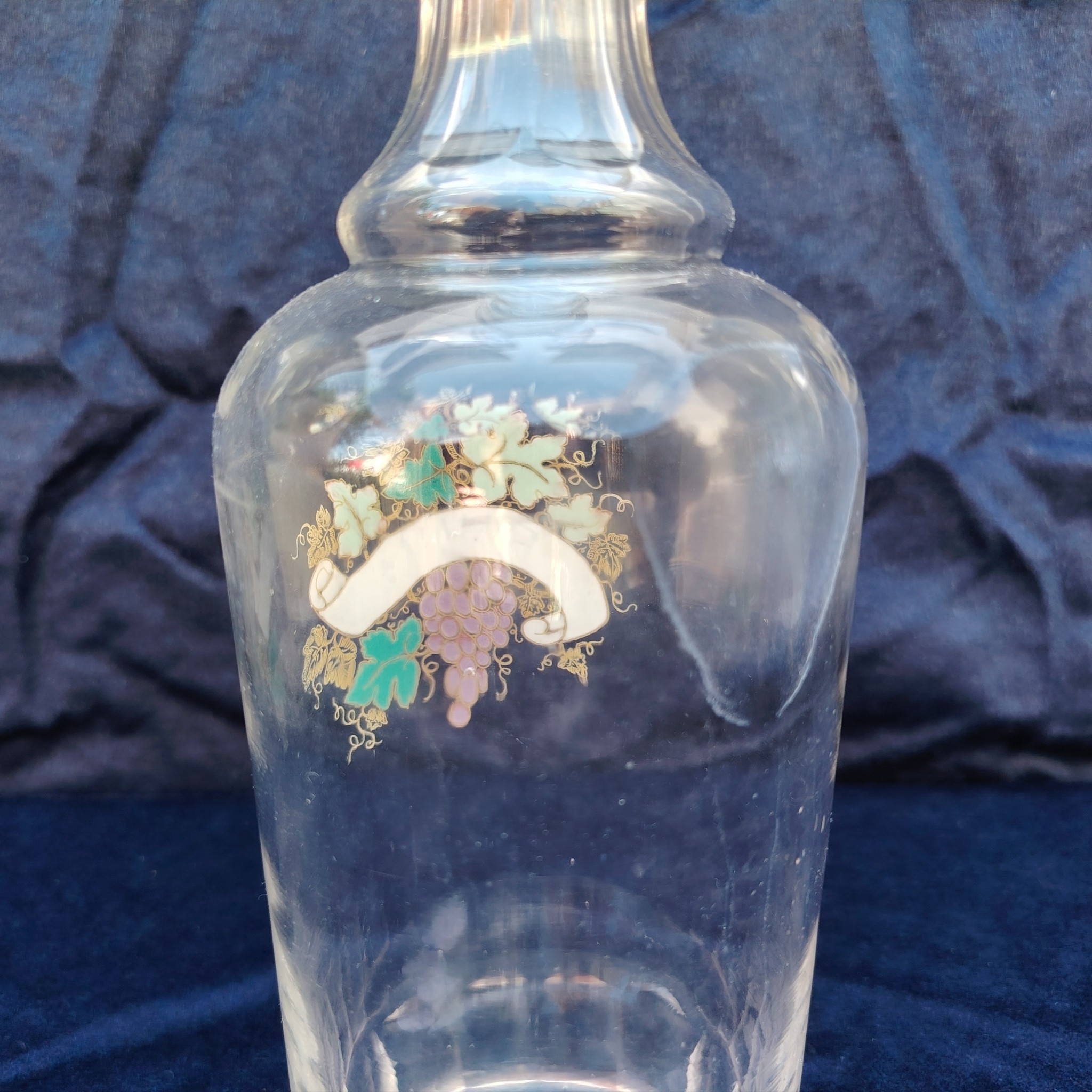 Ancienne bouteille en verre taillé à facette, décor émaillé en relief, marqué Rhum. (Idéale pour faire son rhum arrangé) Des petites traces de calcaire et traces d'usage. Bon état général Hauteur : 30 cm