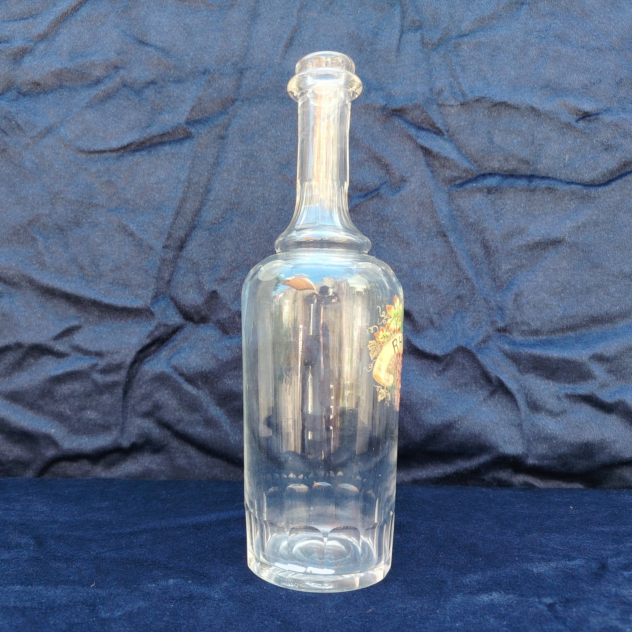 Ancienne bouteille en verre taillé à facette, décor émaillé en relief, marqué Rhum. (Idéale pour faire son rhum arrangé) Des petites traces de calcaire et traces d'usage. Bon état général Hauteur : 30 cm