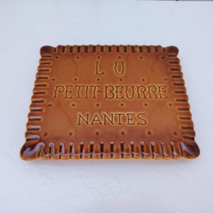 Dessous de plat publicitaire de la marque Lu pour les petits-beurre, à la forme mythique du biscuit. Excellent état. Dimensions : 25 x 21,5 cm