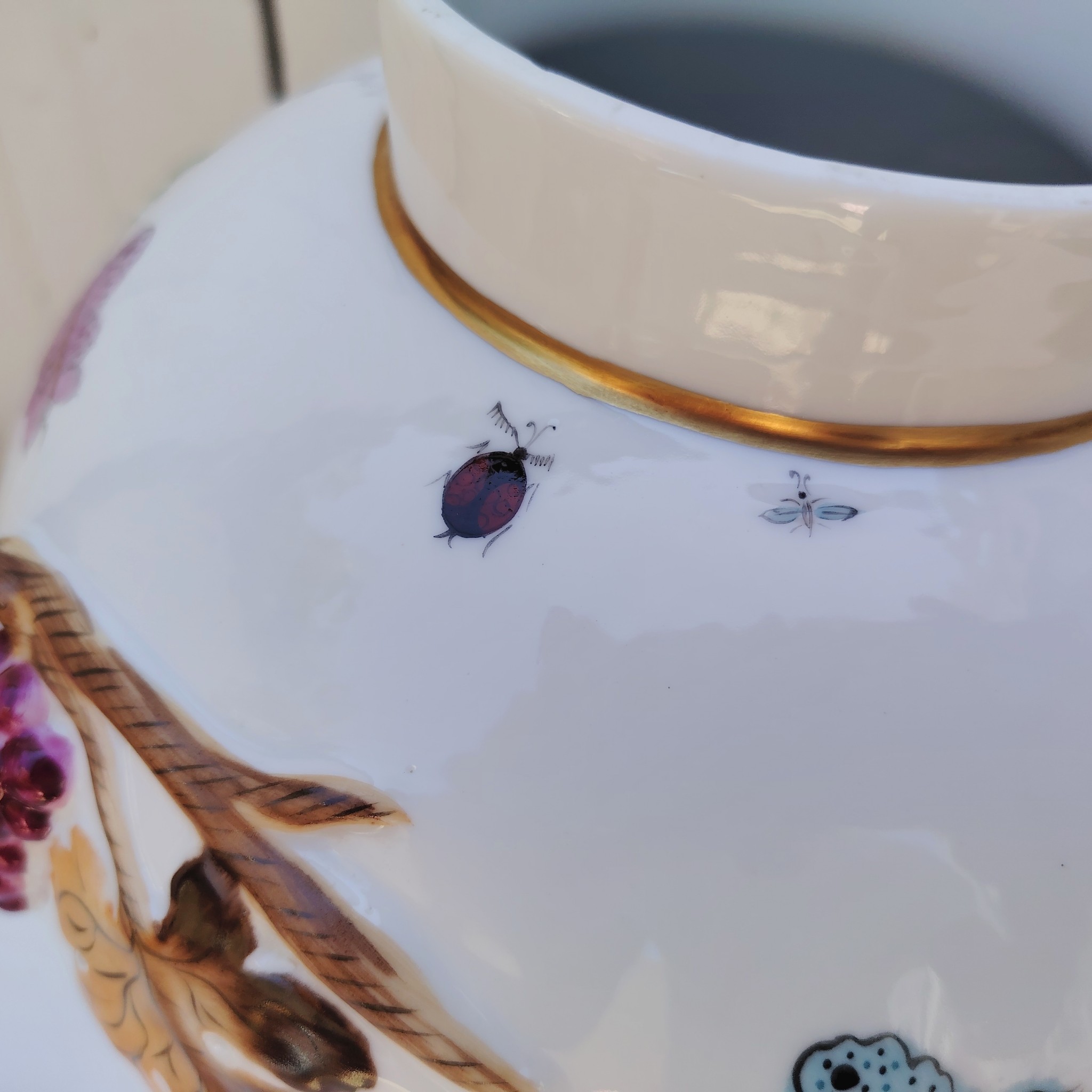 Grand pot couvert en porcelaine portugaise Pac. Orné de vignes et grappes de raisins en relief, et de papillons et coccinelles peints. Liseré doré, poignée du couvercle représentant une branche dorée surhaussé d'un perroquet. Très belle facture. Excellent état.  Hauteur avec couvercle : ~47 cm