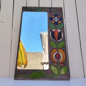 Miroir à poser en pierre de lave avec fleurs colorées émaillées, traces sur le miroir probablement la colle que l'on voit au travers. Très bel objet déco. Bon état général. Dimensions : 50 x 30 cm