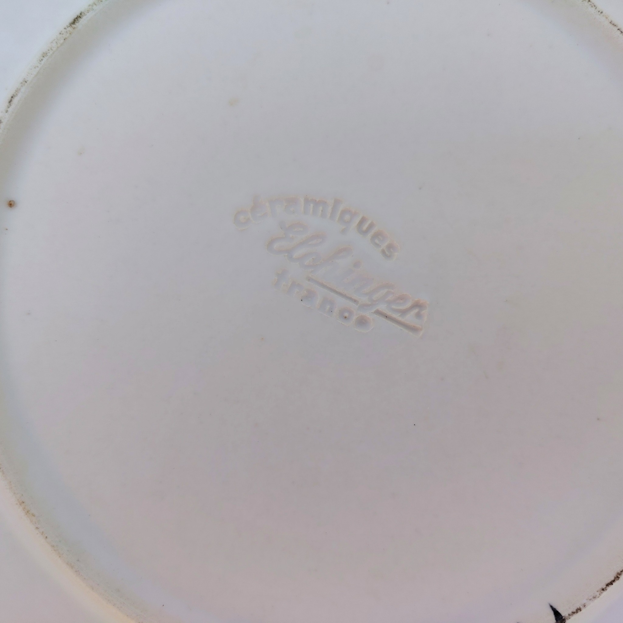 Plateau et cloche à fromage en céramique datant des années 60, par Elchinger. Plusieurs noms de fromages sur la cloche et le plateau. Des petites rayures d'usage, Signé sur le dessous. Bon état général . Hauteur avec cloche : 14,5 cm Diamètre : 28,5 cm