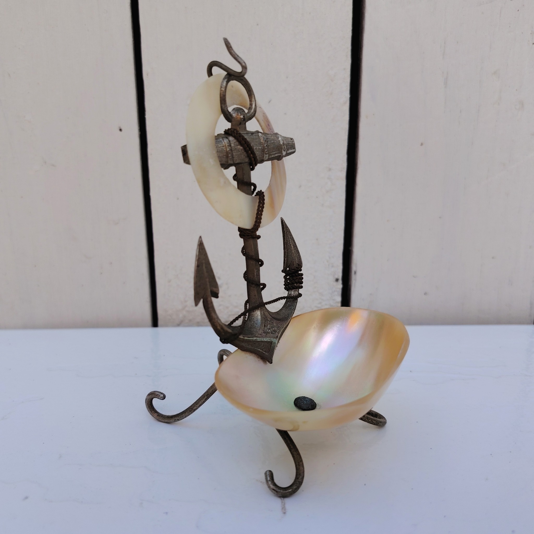 Porte-montre ou baguier en coquillage et ancre de marine en métal argenté, souvenir de Fécamp. Noté Fécamp sur l'anneau en coquillage. Très bon état Hauteur : 10,5 cm