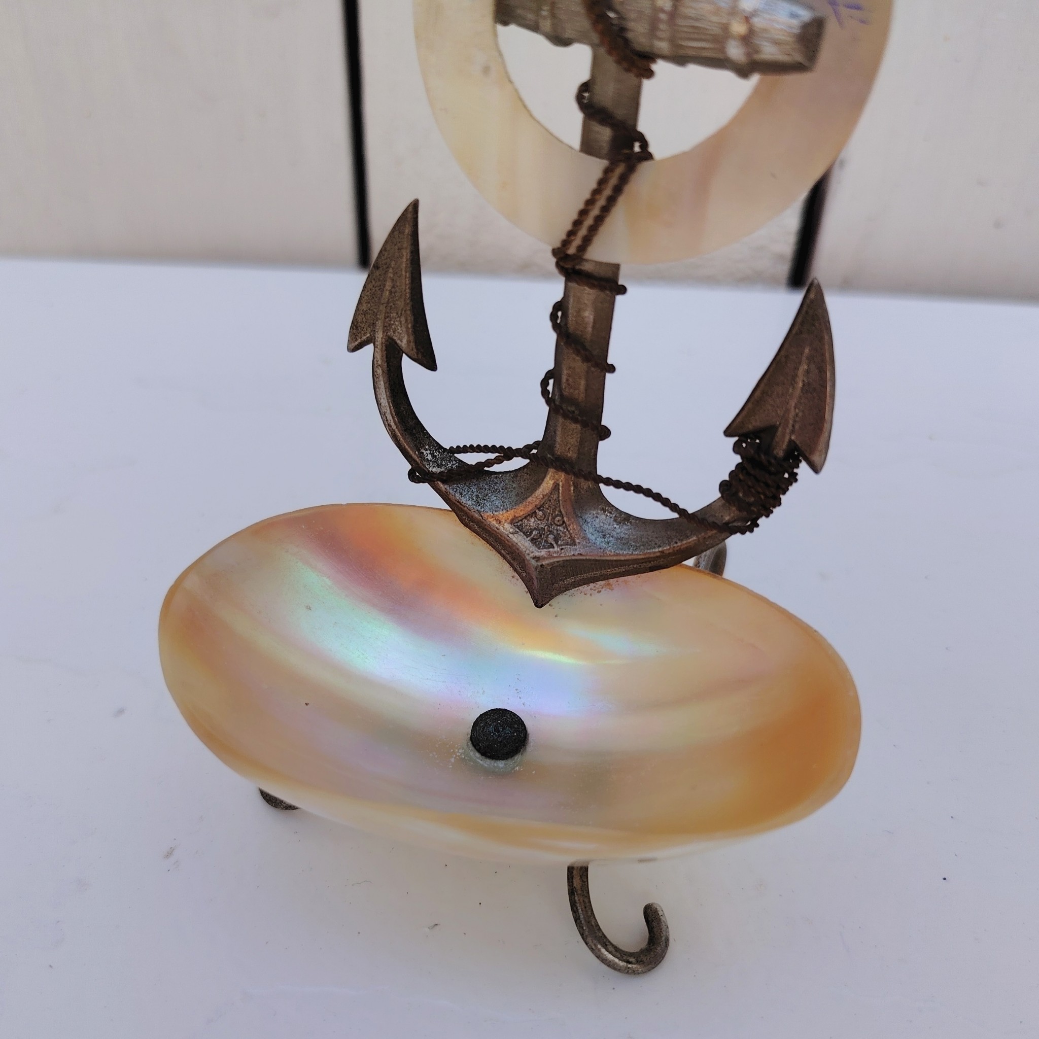 Porte-montre ou baguier en coquillage et ancre de marine en métal argenté, souvenir de Fécamp. Noté Fécamp sur l'anneau en coquillage. Très bon état Hauteur : 10,5 cm