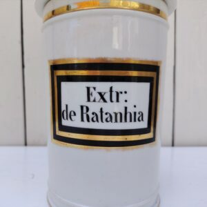 Grand pot d'apothicaire en porcelaine de Paris. Inscription : Extr : de Ratanhia. Manque de dorure sur la prise du couvercle, sur le contour de l'inscription ainsi que les liserés Bon état général Hauteur avec couvercle : 28 cm Diamètre : 12 cm