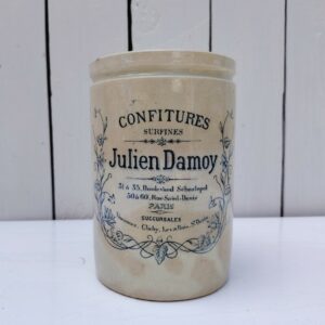 Ancien pot de confitures surfines en céramique de la marqueJulien Damoy à Paris Jaunissure et brunissement du pot. Un petit éclat sur le contour, et craquelé à l'intérieur. Hauteur : 15,5 cm Diamètre : 10,5 cm