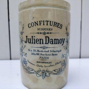 Ancien pot de confitures surfines en céramique de la marqueJulien Damoy à Paris Jaunissure et brunissement du pot. Un petit éclat sur le contour, et craquelé à l'intérieur. Hauteur : 15,5 cm Diamètre : 10,5 cm