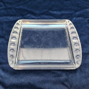 Vide poche en cristal par René Lalique, modèle Ermitage. Quelques petits éclats sur le coins à peine visible, traces et petites rayures d'usage. Bon état général. Dimensions : 17,5 x 14 x 2 cm 