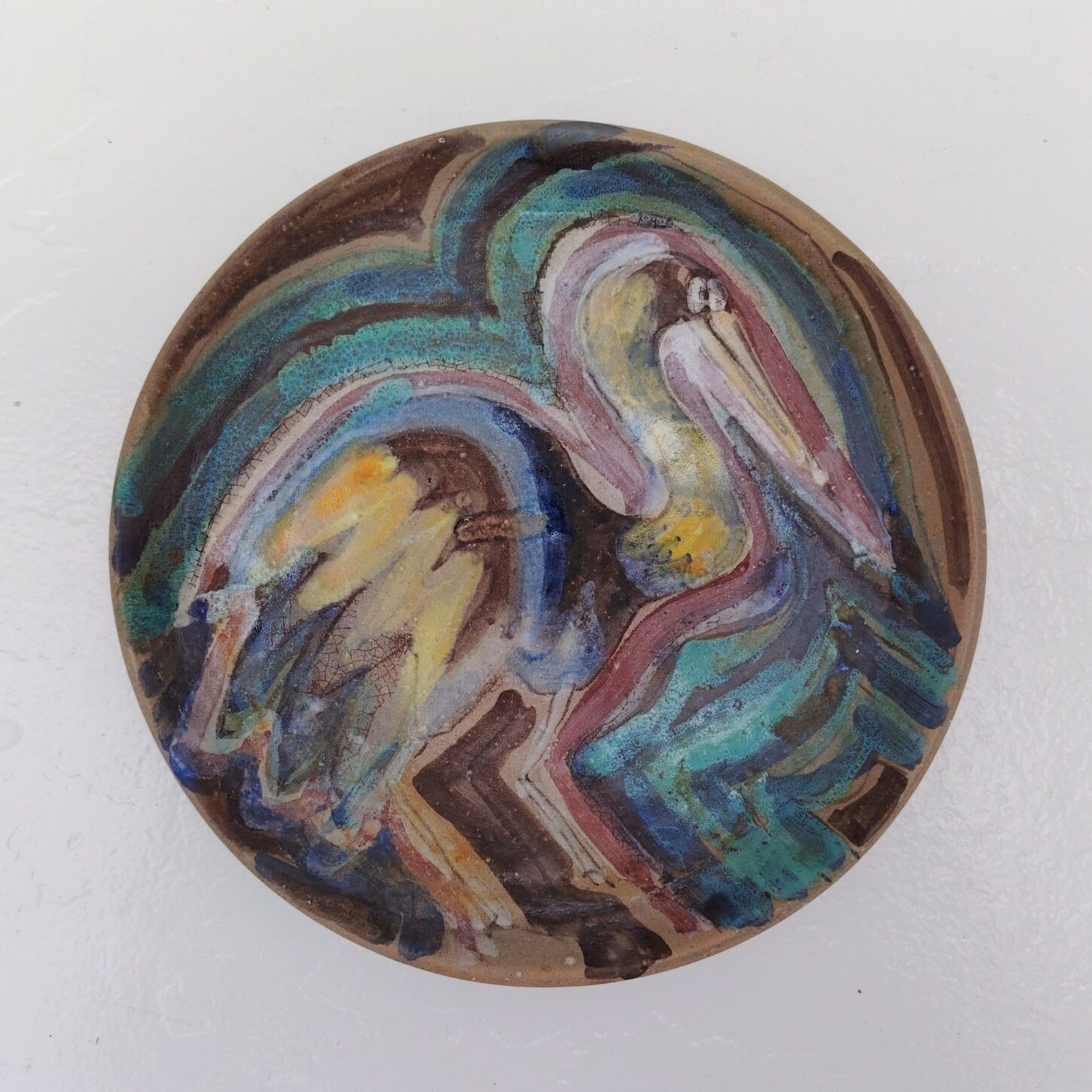 Assiette en céramique décor d'oiseau coloré , un marabout ou pélican . Signée sur le dessous. Très bon état Diamètre : 20,5 cm