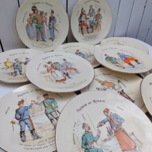 12 assiettes polychromes montrant pour chacune un militaire de chaque pays en vis-à-vis, intitulée France et Russie.De la faîencerie Keller et Guerin à Lunéville. Elles célèbrent l'alliance franco-russe, rappelant la visite de la flotte française à Cronstadt en 1891 et celle de la flotte russe à Toulon en 1893. Une paillette recollée sur une assiette, trace d'usage et petits manque de polychromies. Bon état général Diamètre : 22 cm