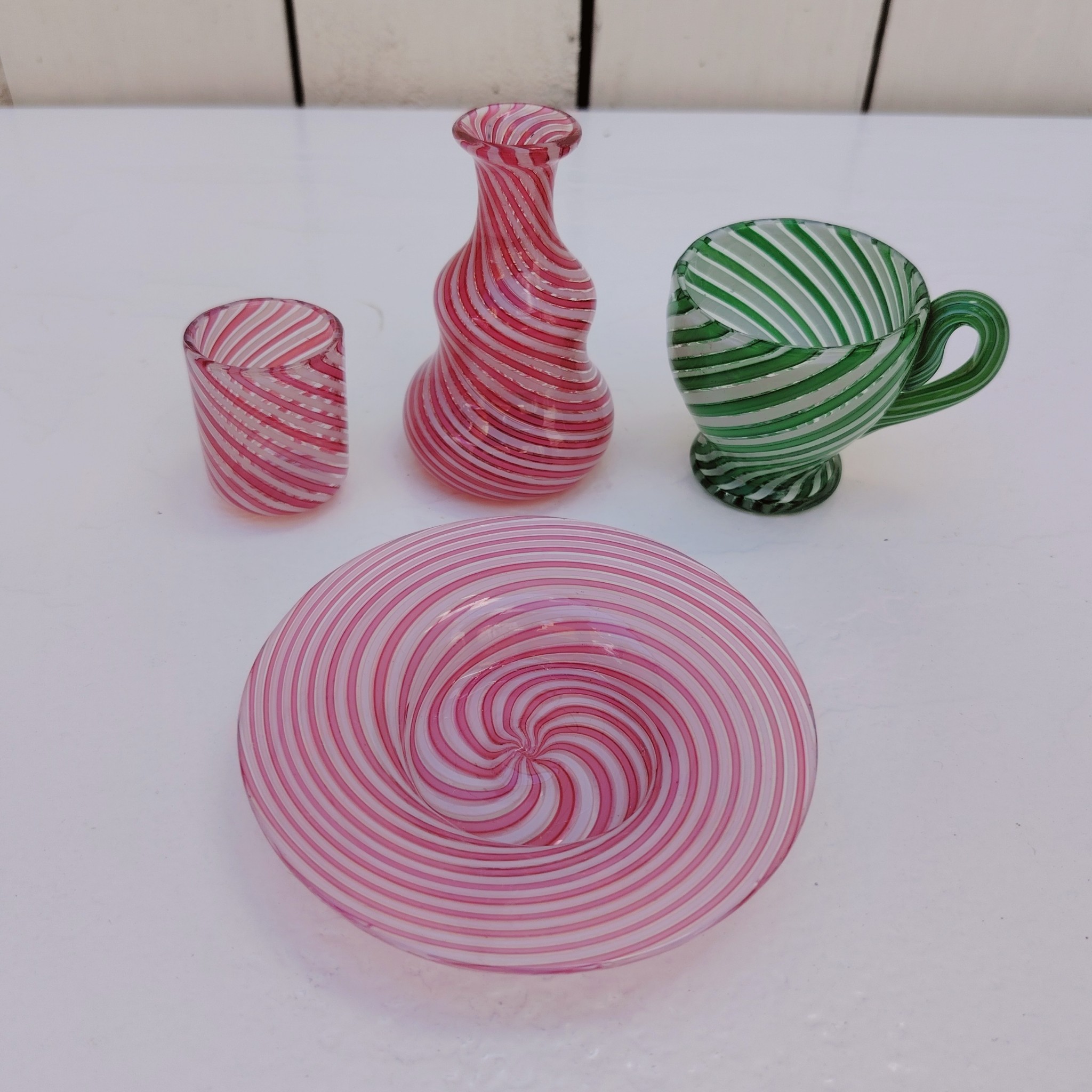 Lot dînette e en verre soufflé de Murano, Composé d'une petite assiette, un gobelet, une cruche de couleur rose et une tasse de couleur verte Excellent état Hauteur gobelet : 3,5 cm diamètre : 3 cm Hauteur cruche : 7 cm Hauteur tasse : 5 cm diamètre : 4,5 cm Diamètre assiette : 9 cm