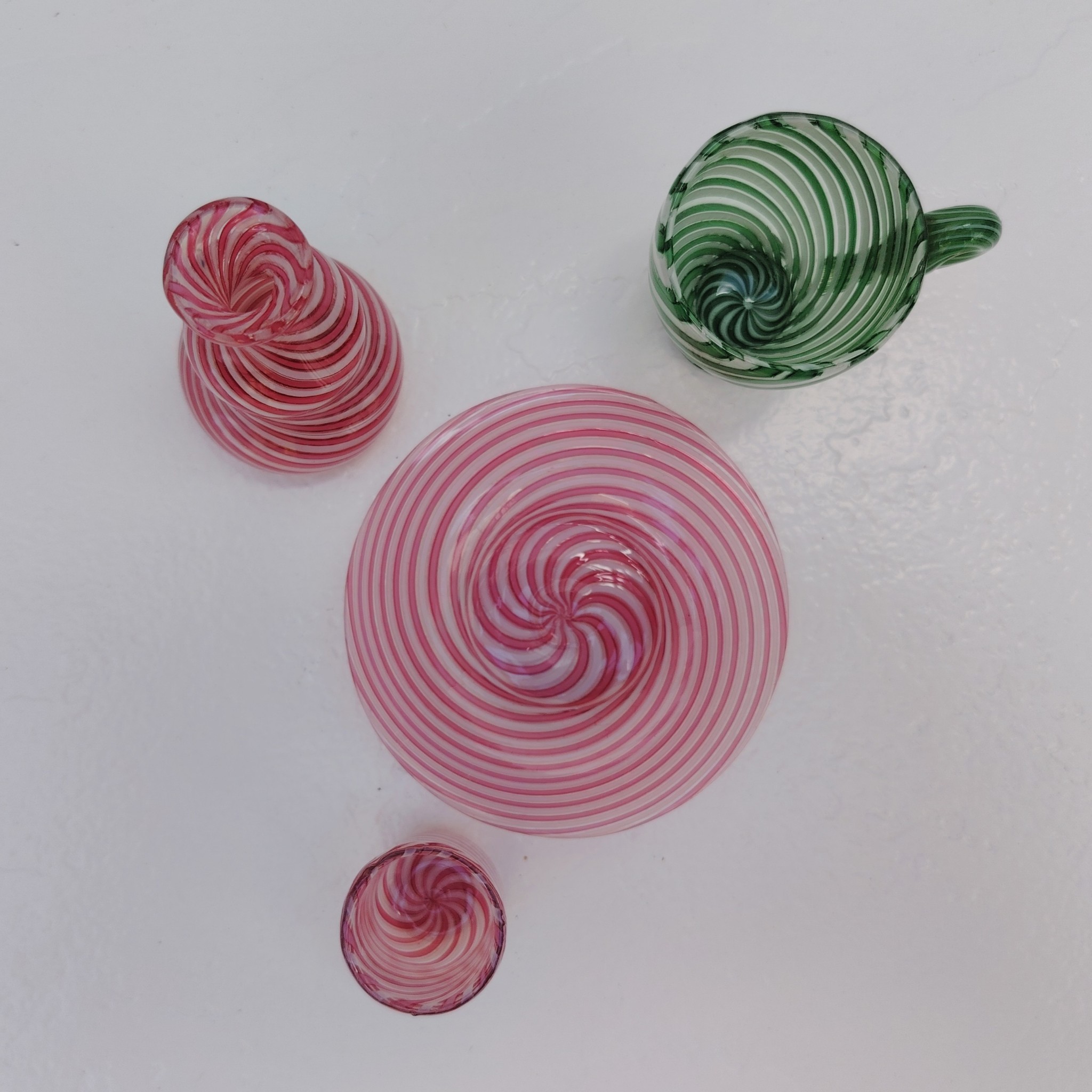 Lot dînette e en verre soufflé de Murano, Composé d'une petite assiette, un gobelet, une cruche de couleur rose et une tasse de couleur verte Excellent état Hauteur gobelet : 3,5 cm diamètre : 3 cm Hauteur cruche : 7 cm Hauteur tasse : 5 cm diamètre : 4,5 cm Diamètre assiette : 9 cm