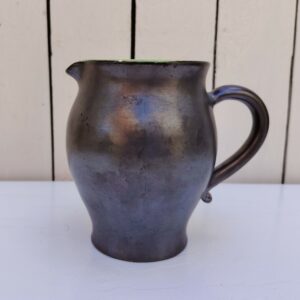 Pichet en céramique noire irisée sur l'extérieur et vert brillant sur l'intérieur en faïence. Petites égrenures au bec et au pied Bon état général Hauteur : 14,5  cm Diamètre : 9,5  cm