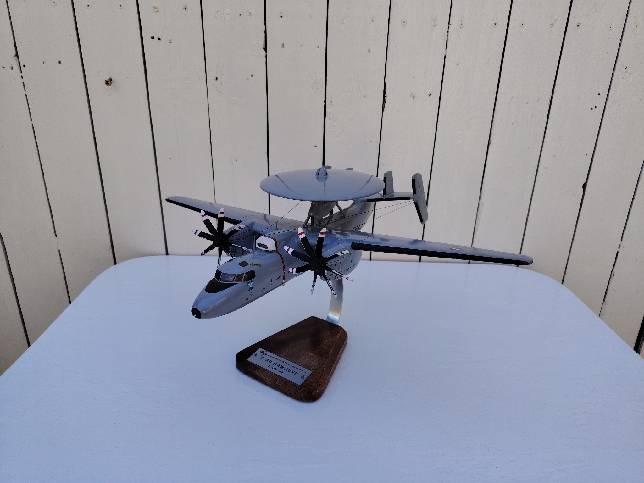Maquette avion aux couleurs de la Flottille 4F de l'Aéronavale Française. Modèle: E2C-Hawkeye, Réalisation en bois massif, sculptée et peinte à la main. Sur socle en Acacia vernis avec plaquette gravée. De la marque Pilot station. Petites traces et rayures d'usage. Bon état général Dimensions : 37x49x 24 cm