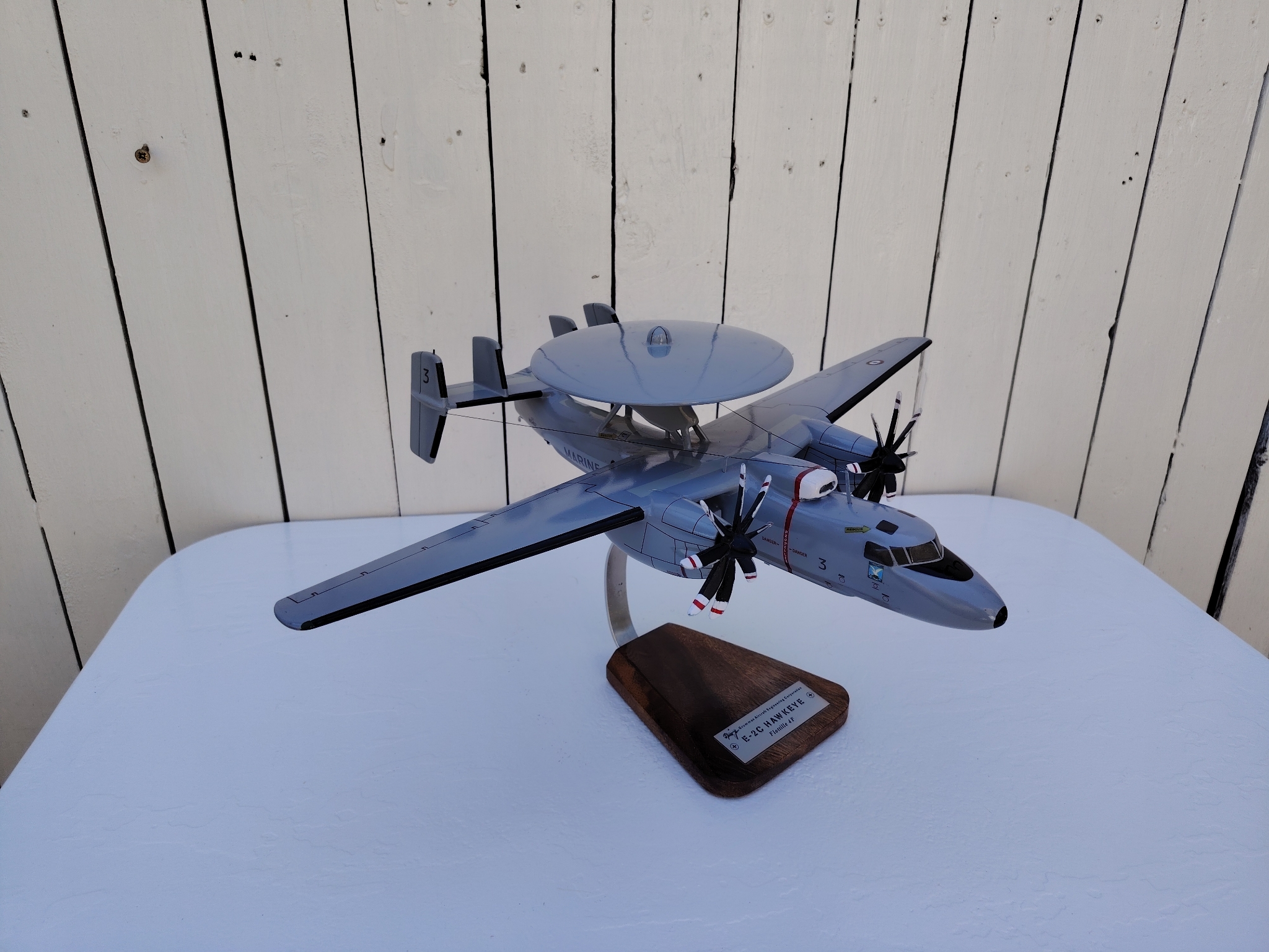 Maquette avion aux couleurs de la Flottille 4F de l'Aéronavale Française. Modèle: E2C-Hawkeye, Réalisation en bois massif, sculptée et peinte à la main. Sur socle en Acacia vernis avec plaquette gravée. De la marque Pilot station. Petites traces et rayures d'usage. Bon état général Dimensions : 37x49x 24 cm