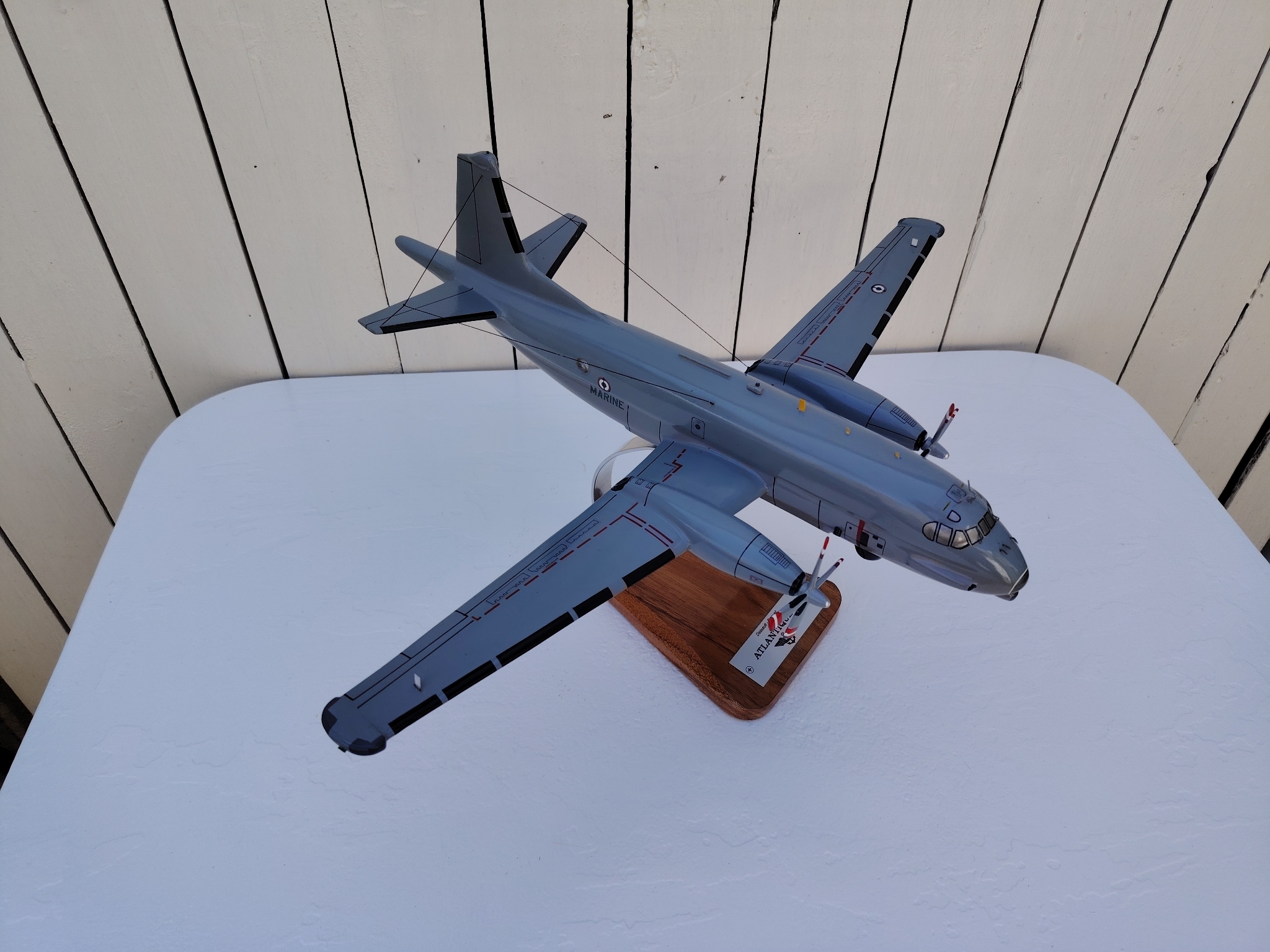 Maquette avion de la marine Française. Modèle: Atlantique 2 Réalisation en bois massif, sculptée et peinte à la main. Sur socle en Acacia vernis avec plaquette gravée. De la marque Pilot station Petites traces et rayures d'usage. Bon état général Dimensions : 45 x 50 x 27 cm