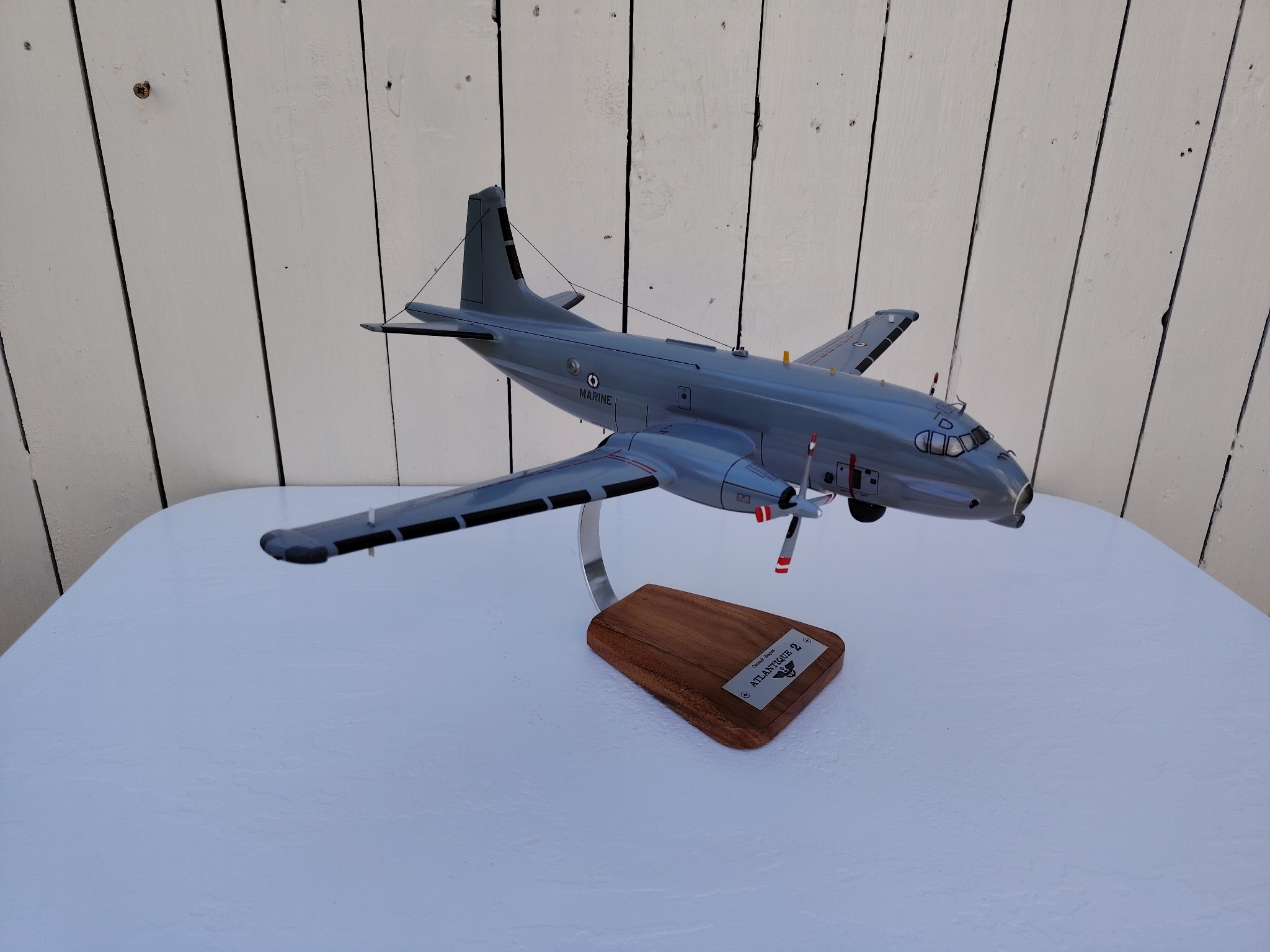 Maquette avion de la marine Française. Modèle: Atlantique 2 Réalisation en bois massif, sculptée et peinte à la main. Sur socle en Acacia vernis avec plaquette gravée. De la marque Pilot station Petites traces et rayures d'usage. Bon état général Dimensions : 45 x 50 x 27 cm
